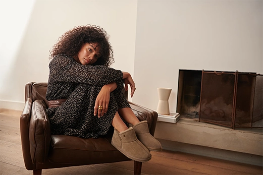 Vrouw zittend op een stoel bij de open haard